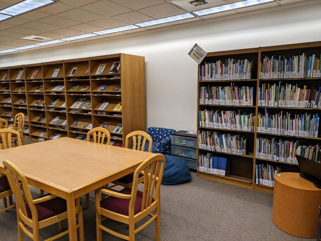 Wide shot of Curriculum Collection's new home in basement surrounded by study tables.